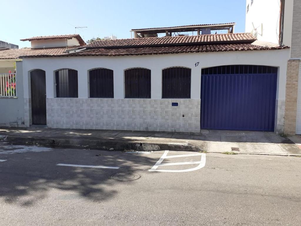 ein Gebäude mit einer lila Tür und einem Parkplatz in der Unterkunft Quarto particular em Vitória in Vitória