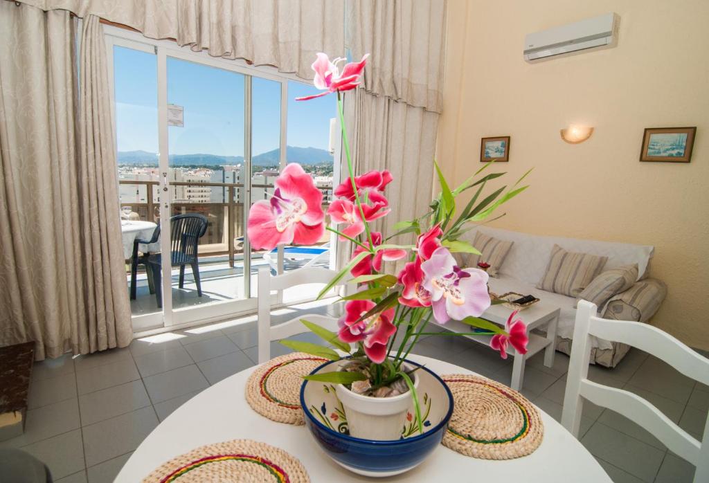 - un salon avec une table et des fleurs dans l'établissement Skol 911A by Completely Marbella, à Marbella