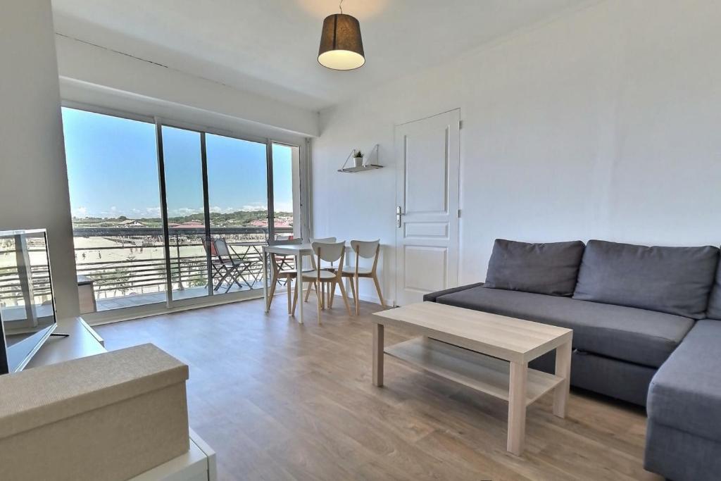 - un salon avec un canapé et une table dans l'établissement Lala Springs Anglet - Vue océan - WIFI - Balcon, à Anglet