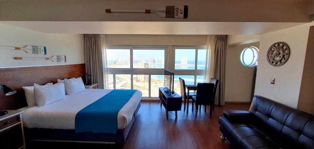 une chambre d'hôtel avec un lit et un canapé dans l'établissement Gran Cavancha Hotel & Apartment, à Iquique