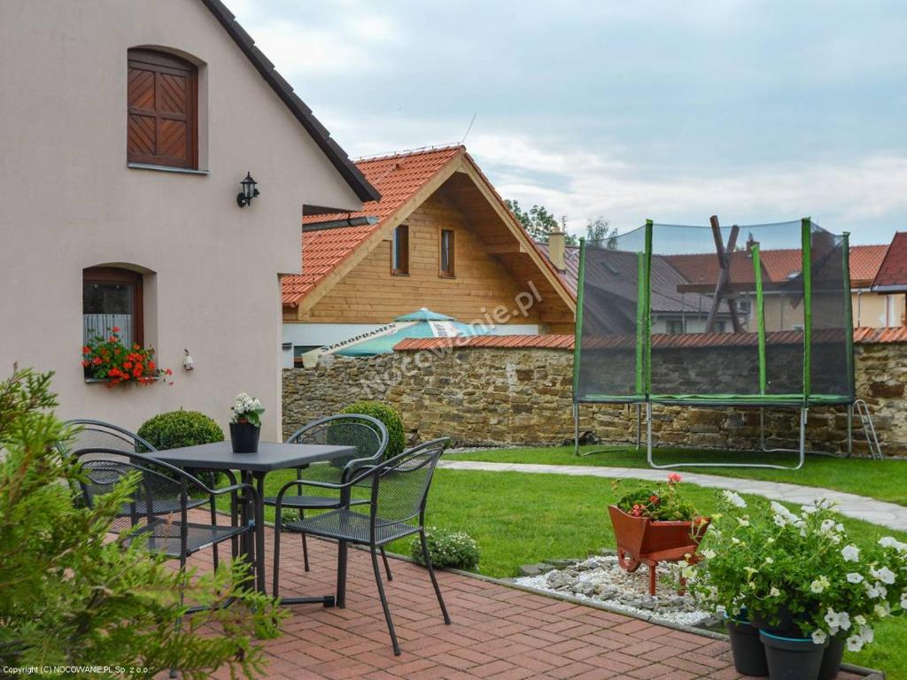 a patio with a table and chairs in a yard at Ubytovanie pod Tatrami in Nová Lesná