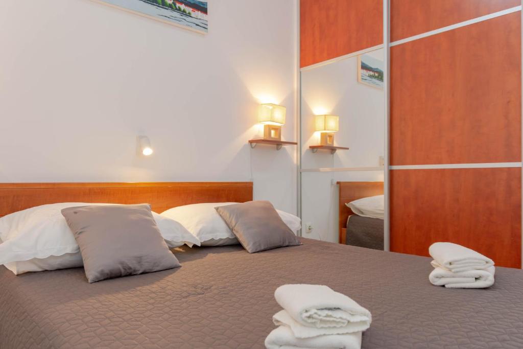a bedroom with two beds with towels on them at Apartman Tradicija in Kaštela