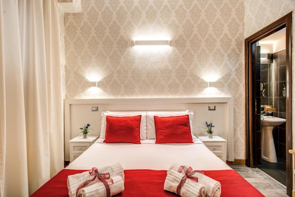 um quarto com uma cama grande e almofadas vermelhas em Auditorium Mecenate em Roma
