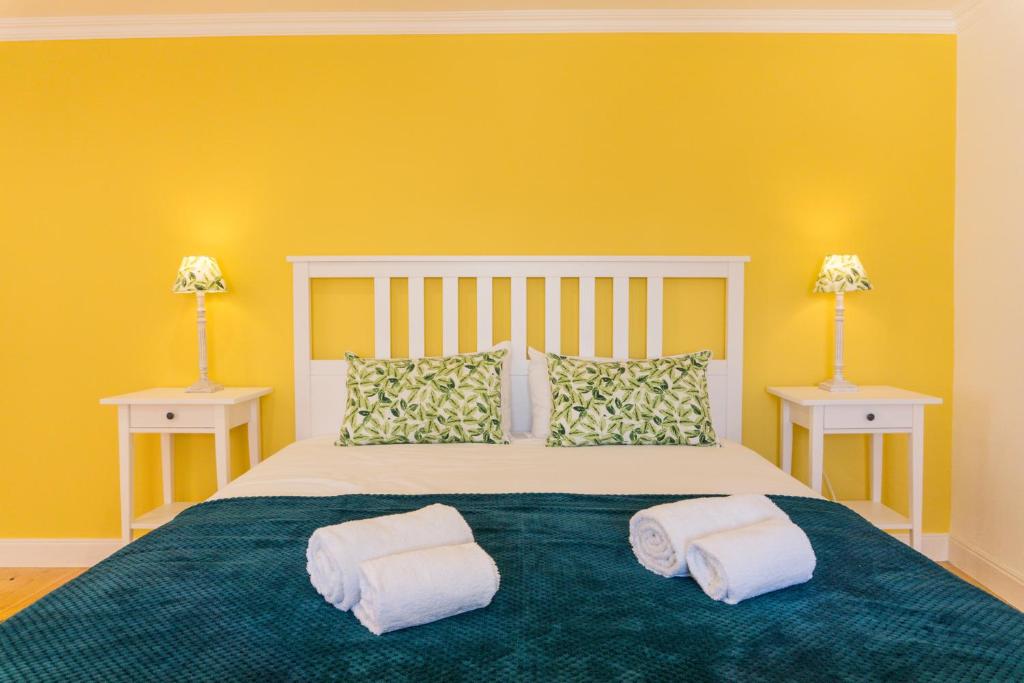 um quarto com uma cama grande e paredes amarelas em Lalitana Townhouse em Lagos