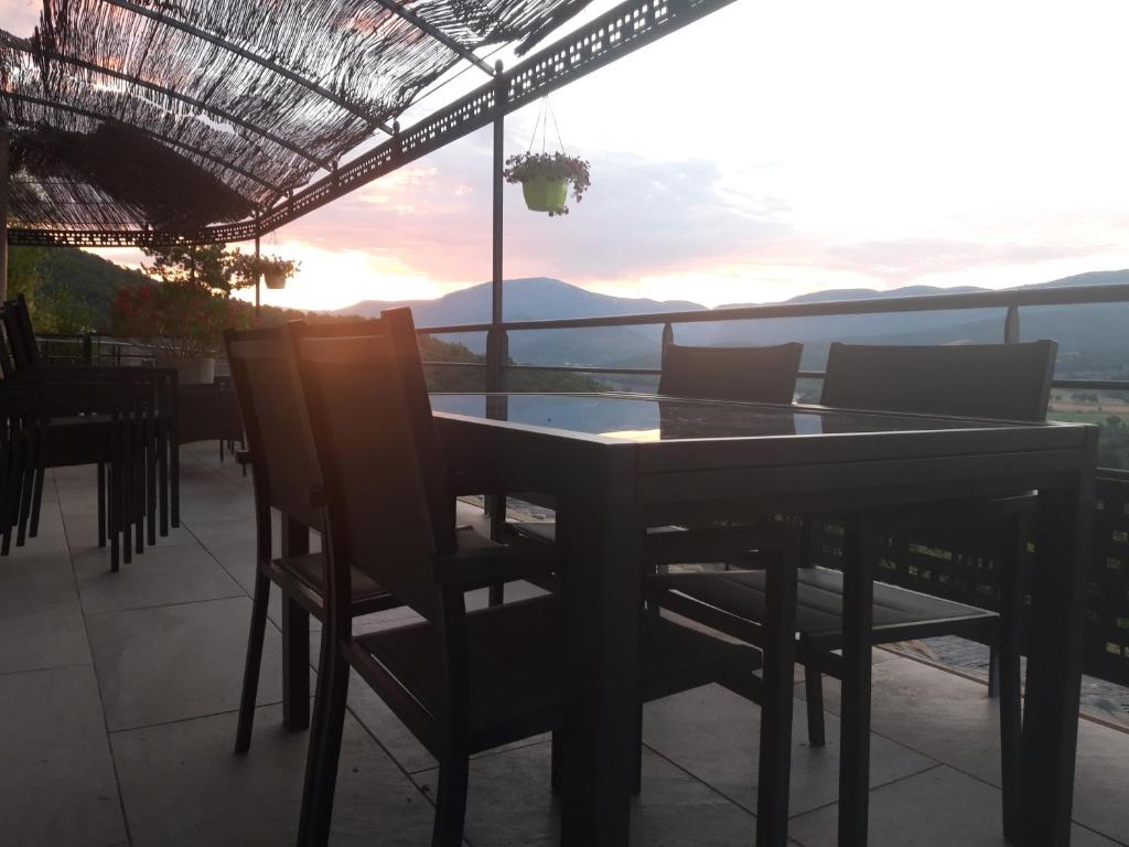 una mesa y sillas en un balcón con vistas en Villabellevie en Bras-dʼAsse