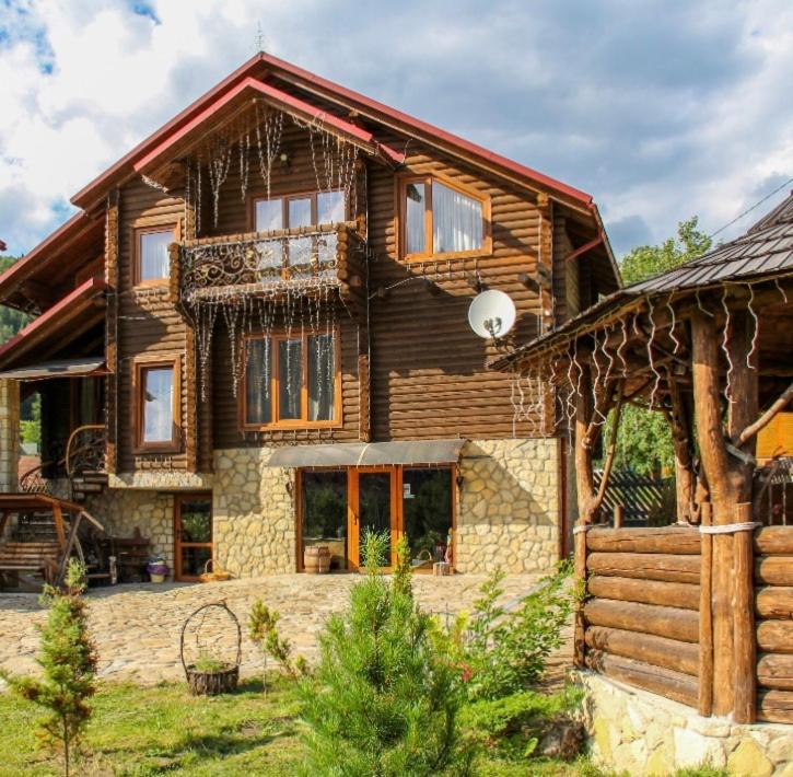 a large wooden house with a porch at Panska Hata in Yaremche