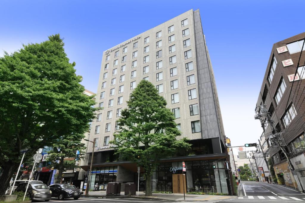 Daiwa Roynet Hotel Sendai Ichibancho PREMIER في سيندايْ: مبنى ابيض كبير امامه شجرة