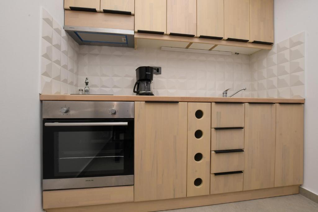a kitchen with a sink and a stove at Orion Eco Suites in Karteros