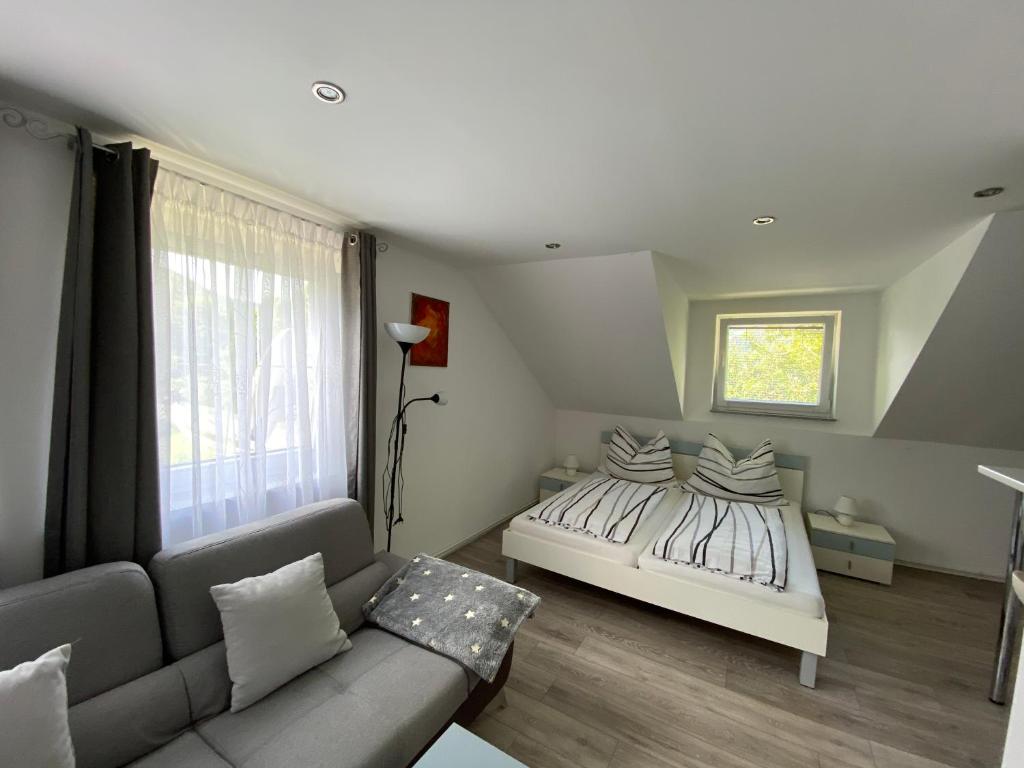 ein Schlafzimmer mit einem Bett und einer Couch in der Unterkunft Ossiach Apartment 1 in Heiligen Gestade