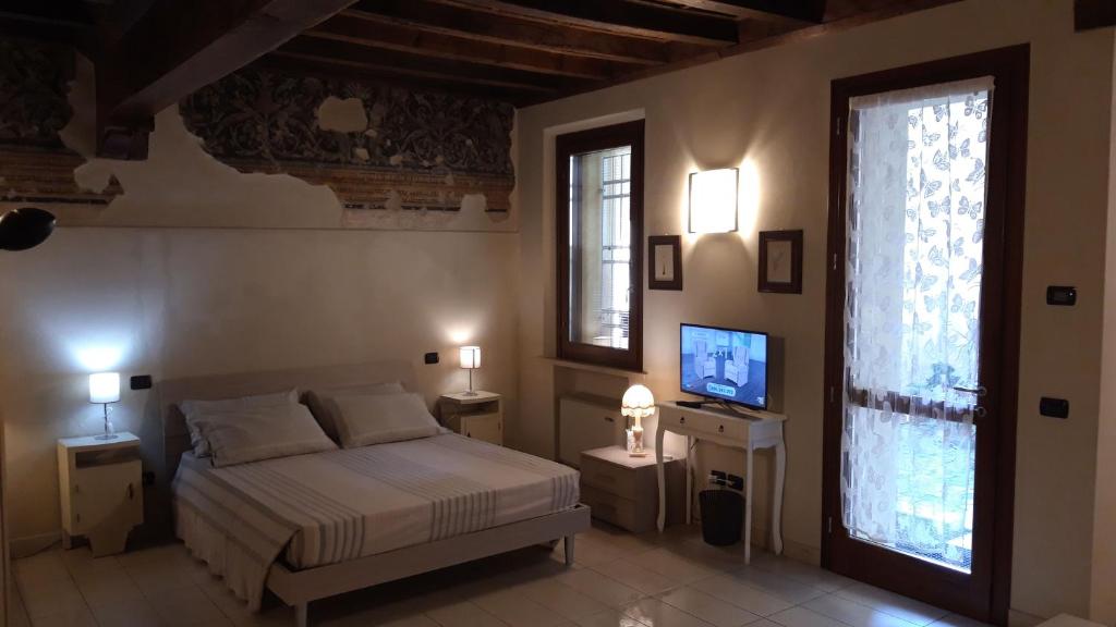 a bedroom with a bed and a television in it at AKANTHO apartment in Mantova