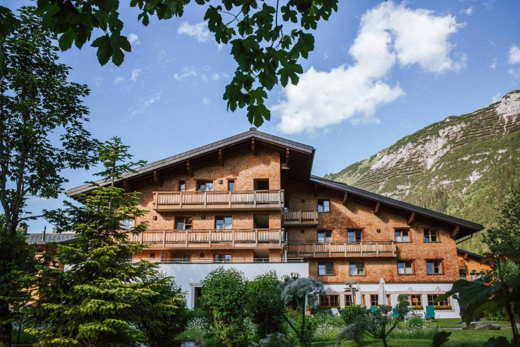 a large brick building with a balcony at Hotel Aurora in Lech am Arlberg