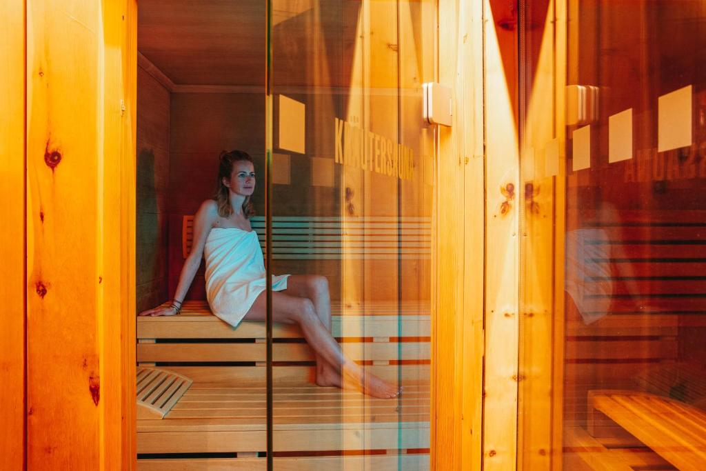 a woman in a dress sitting in a room at Hotel Aurora in Lech am Arlberg