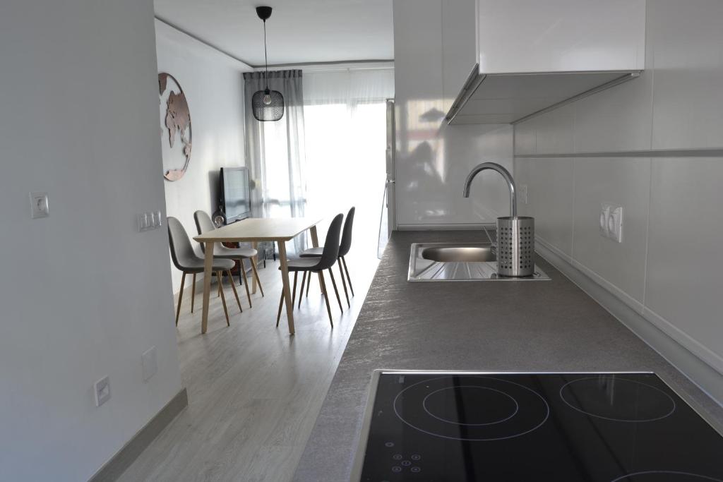 a kitchen with a sink and a table with chairs at El Encanto in Fuengirola