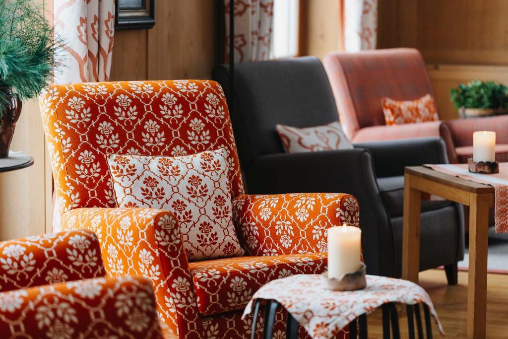 a living room with a chair and a table with candles at Hotel Aurora in Lech am Arlberg