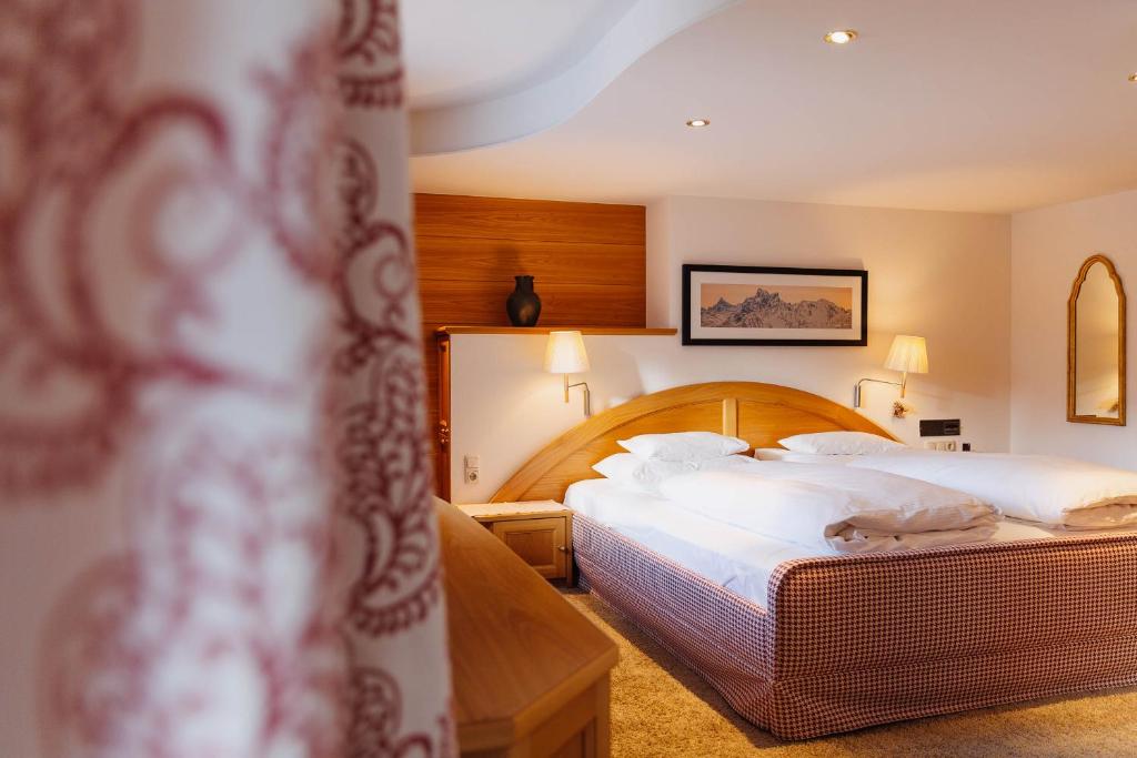 a hotel room with two beds and a mirror at Hotel Aurora in Lech am Arlberg