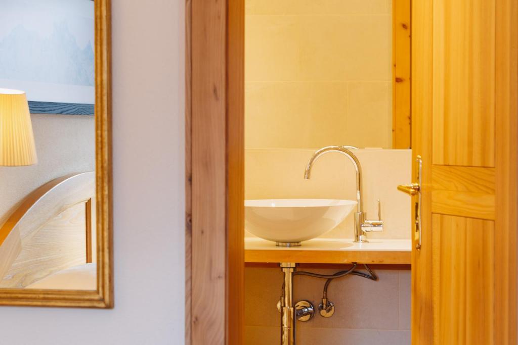 a bathroom with a sink and a mirror at Hotel Aurora in Lech am Arlberg