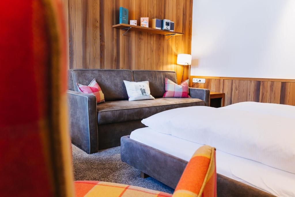 a hotel room with a bed and a couch at Hotel Aurora in Lech am Arlberg