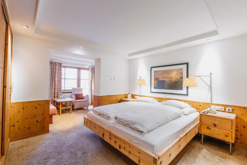 a bedroom with a large bed and a desk at Hotel Aurora in Lech am Arlberg