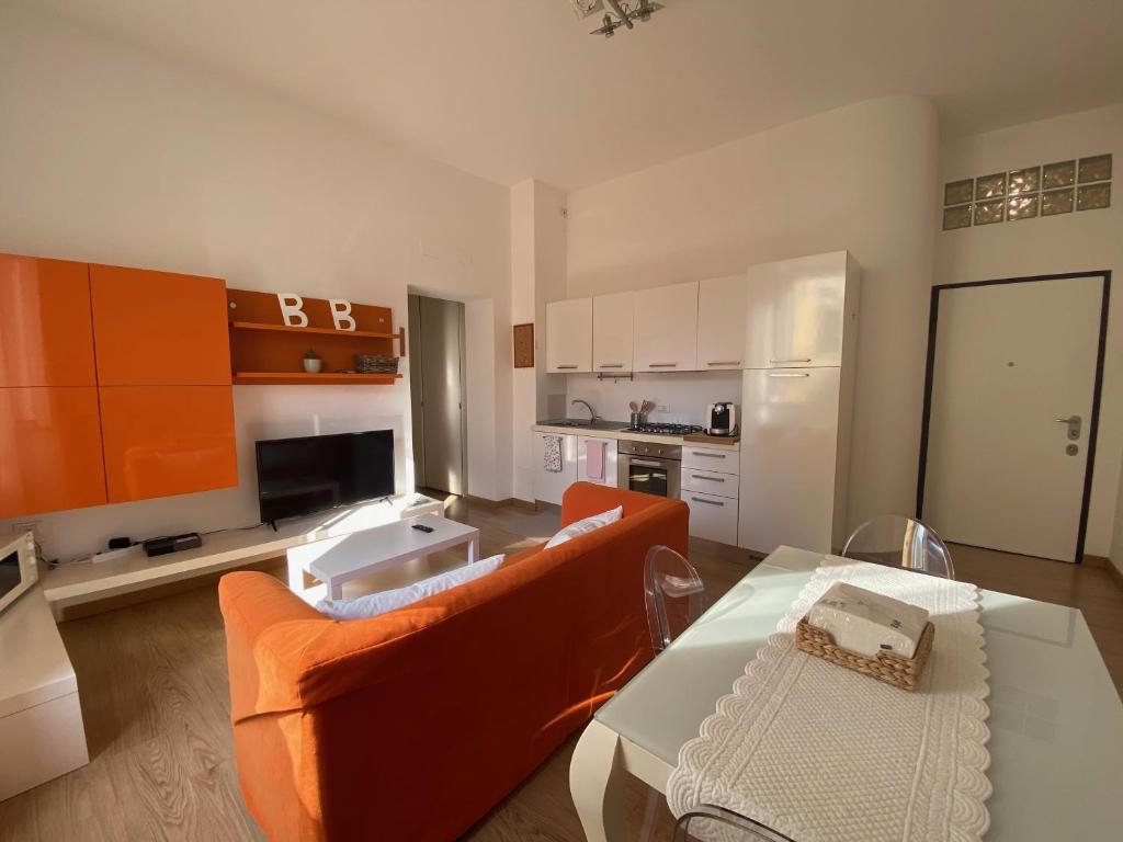 a living room with an orange couch and a table at PALAZZO MARCHETTI in Ancona