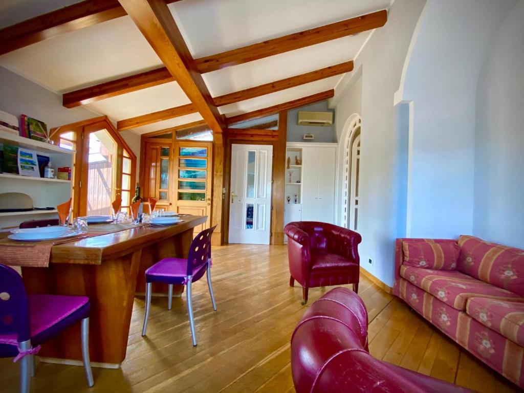 - un salon avec une table en bois et des chaises violettes dans l'établissement Luxury loft casentino, à Bibbiena