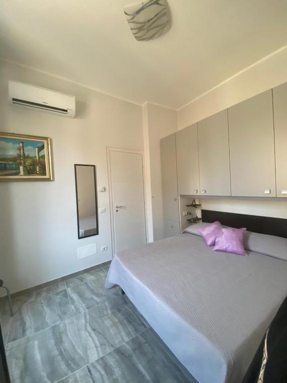 sypialnia z łóżkiem z różową poduszką w obiekcie Casa Viola - Al Centro w Taominie