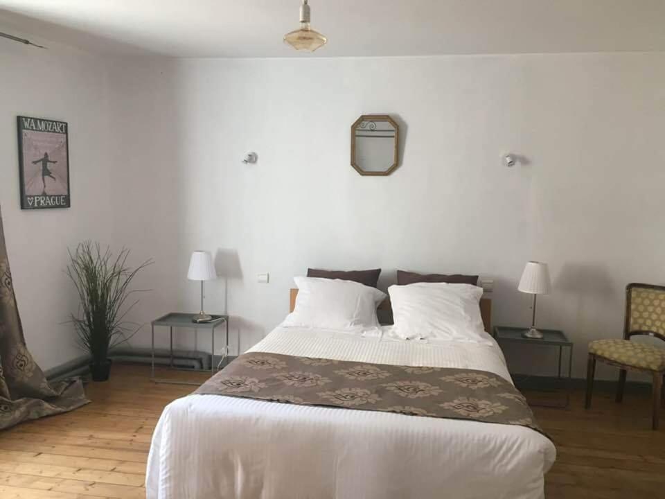 Saint-GaultierにあるLes Oiseaux de Passageのベッドルーム1室(大型ベッド1台、椅子2脚付)