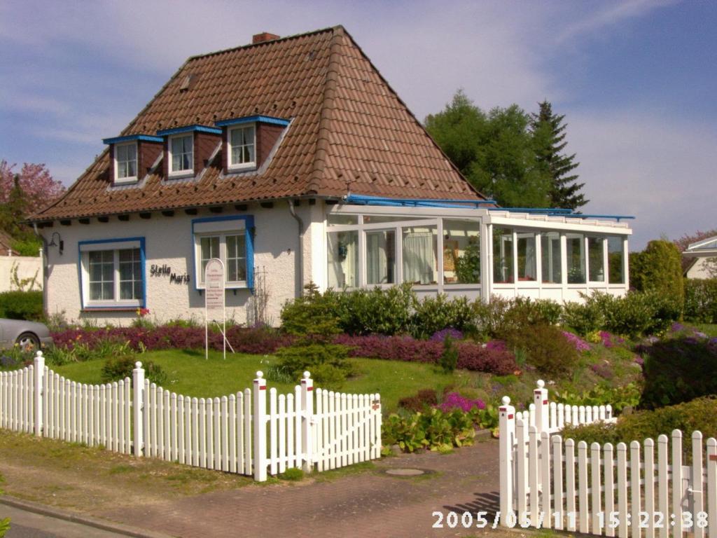 ein Haus mit einem weißen Gartenzaun in der Unterkunft Ferienwohnungen und Ferienhaus im Nixenweg in Hohwacht