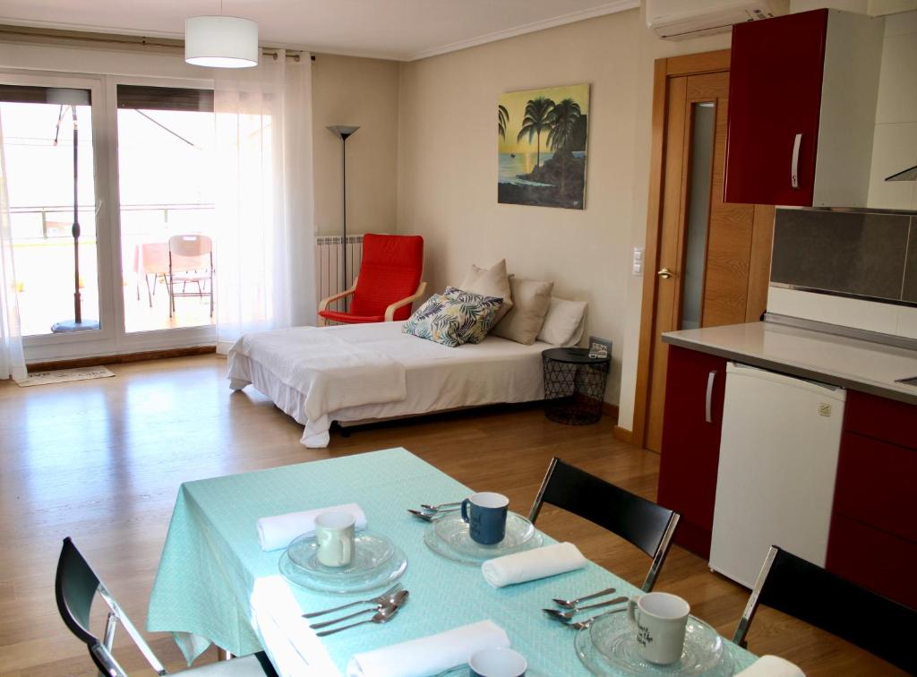 Entrena的住宿－Ático en el centro con terraza y barbacoa，一间带桌子的客厅和一间带床的房间