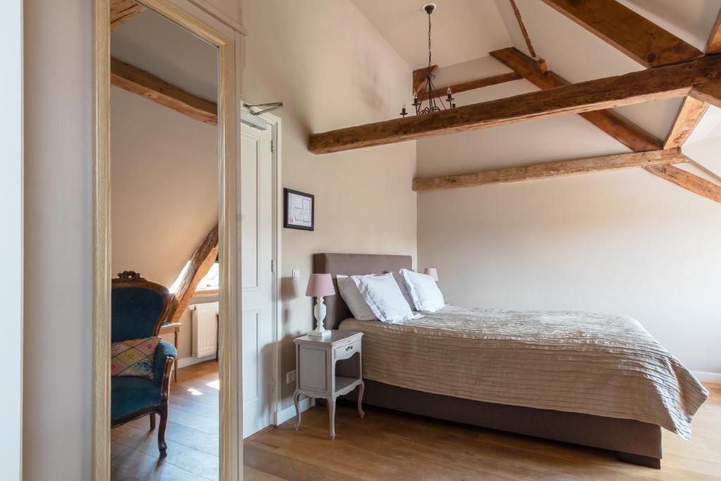 1 dormitorio con cama y espejo en Abbey Abcoude, en Abcoude