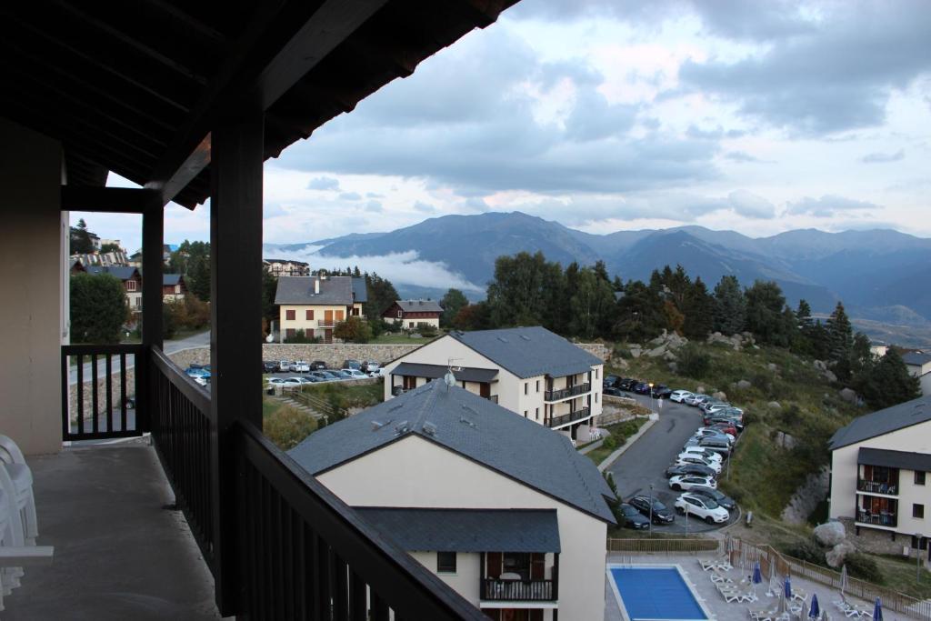 uma varanda de um hotel com vista para um parque de estacionamento e montanhas em Résidence Mille Soleils - Font Romeu em Font Romeu Odeillo Via