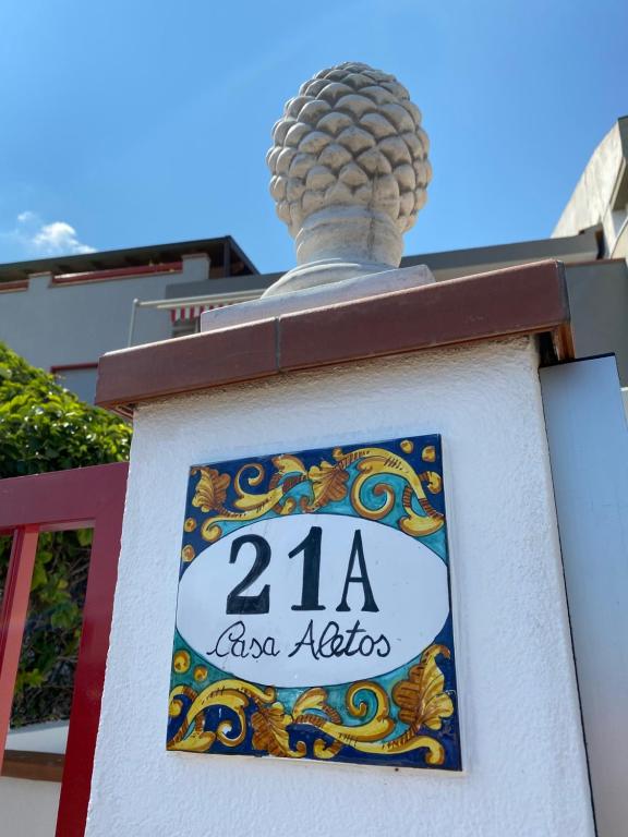 a sign on a building with a statue on top at Casa Aletos Roccalumera-Taormina in Roccalumera