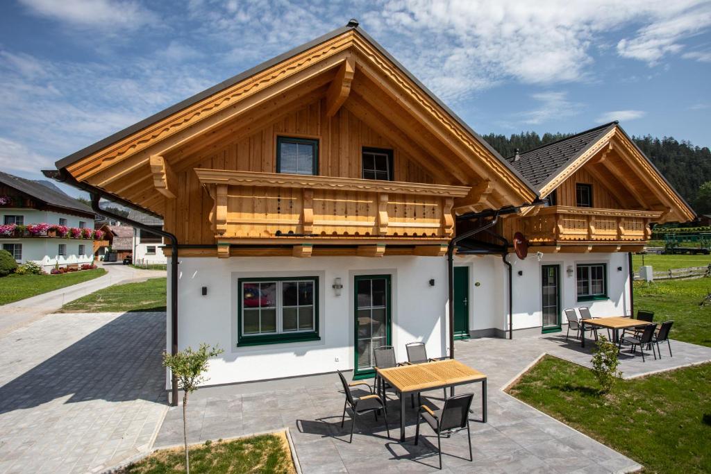 a house with a wooden roof on a patio at Zweimäderlhaus in Bad Mitterndorf