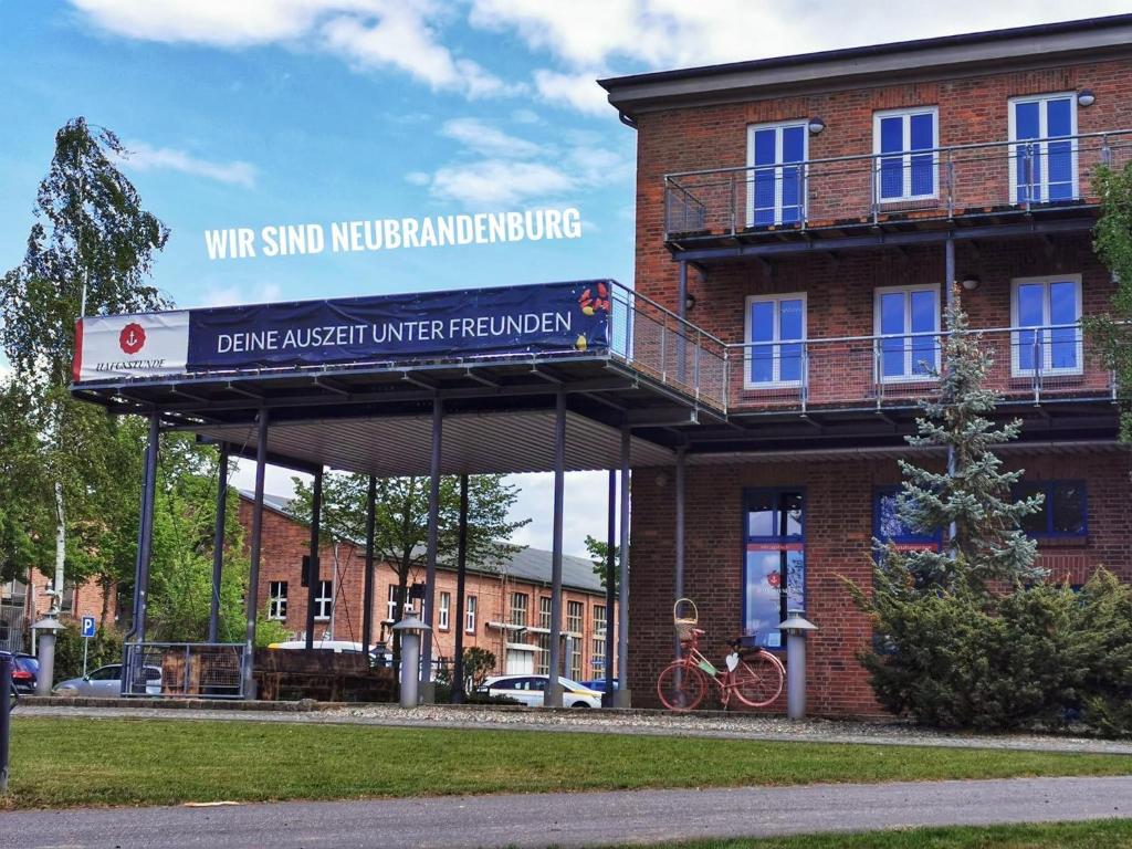 un edificio di mattoni rossi con un cartello sopra di Hafenstunde a Neubrandenburg