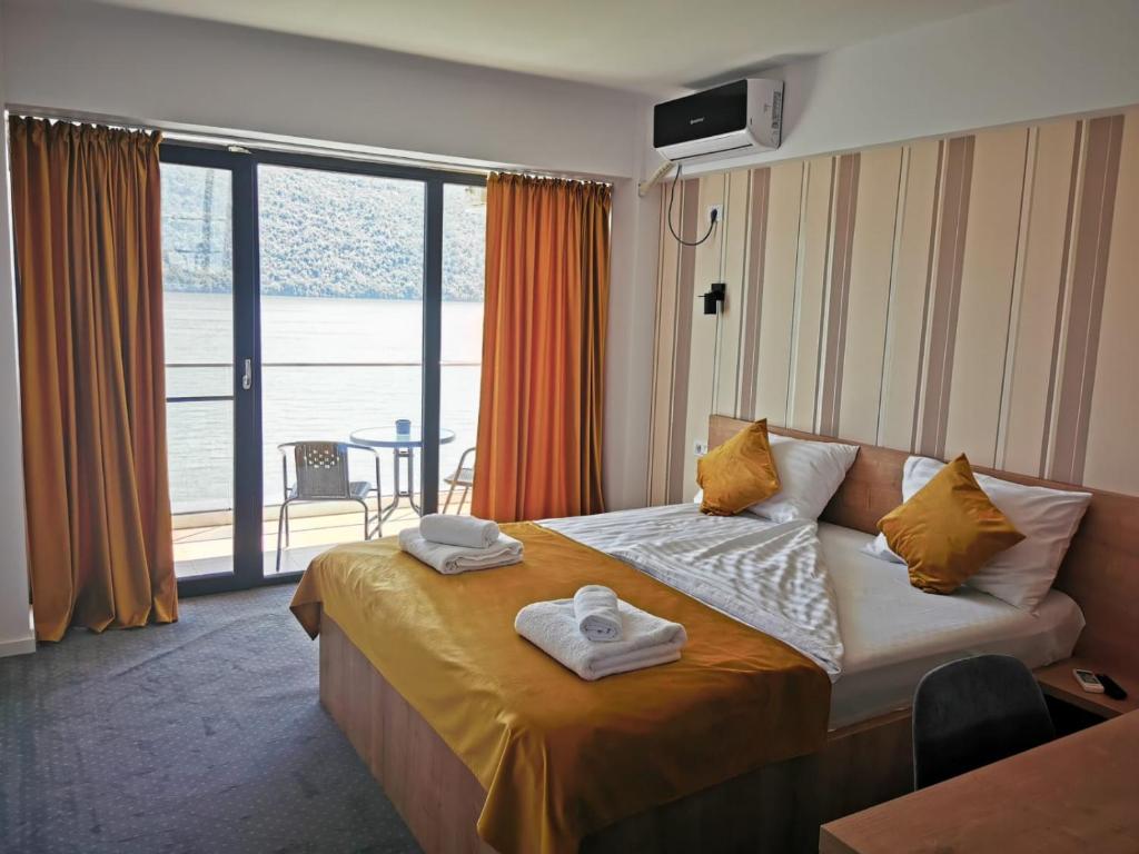 a hotel room with a bed with towels on it at Pensiunea Sunshine in Eşelniţa
