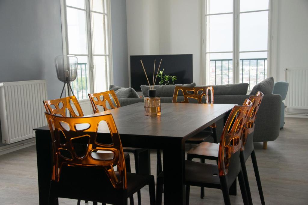 a dining room with a table and chairs at 15ème droite - Tour Perret - Centre-Ville - 4 étoiles in Amiens