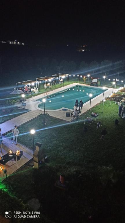 a swimming pool at night with people standing around it at Agriturismo l' Annunziata in Lizzano