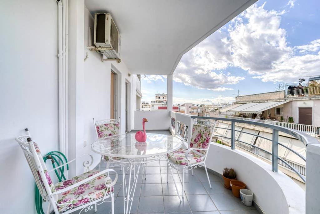 balcón con mesa de cristal y sillas en Cosy and Confortable en Atenas
