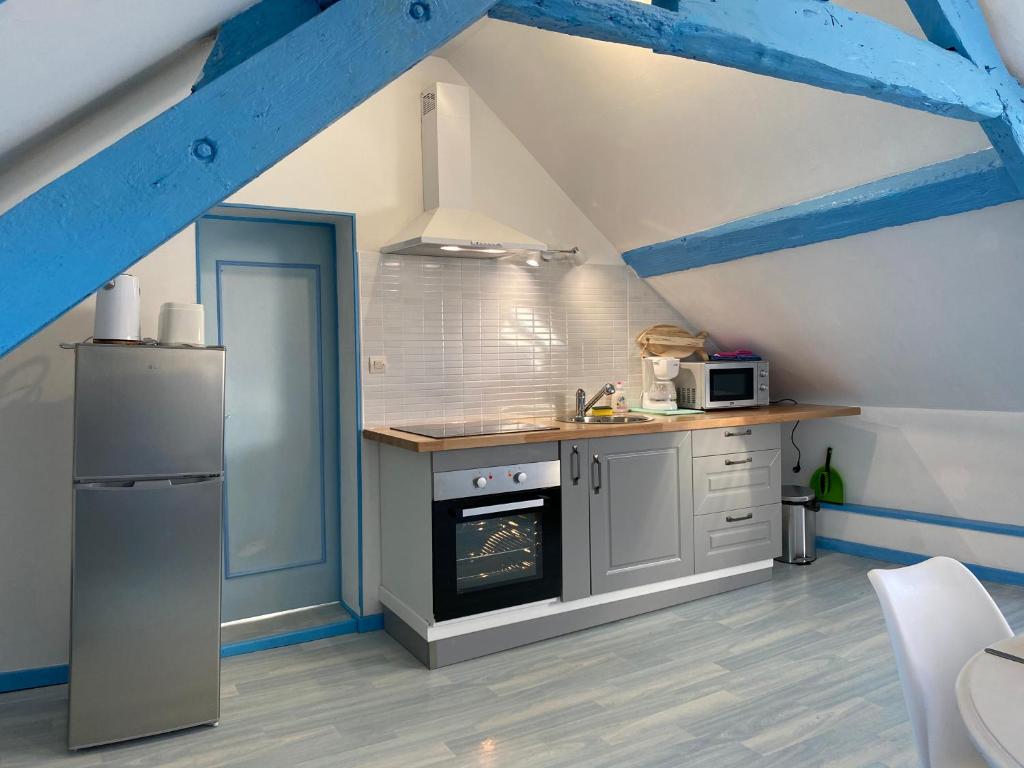 une cuisine avec une cuisinière et un réfrigérateur dans l'établissement Bois Flotté, au Tréport
