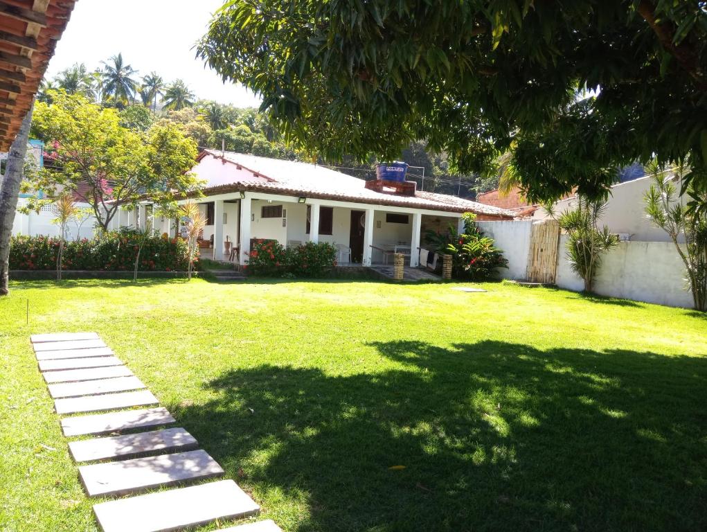 a house with a grass yard with a tree at Casa Porto de Pedras_Patacho_Milagres in Pôrto de Pedras