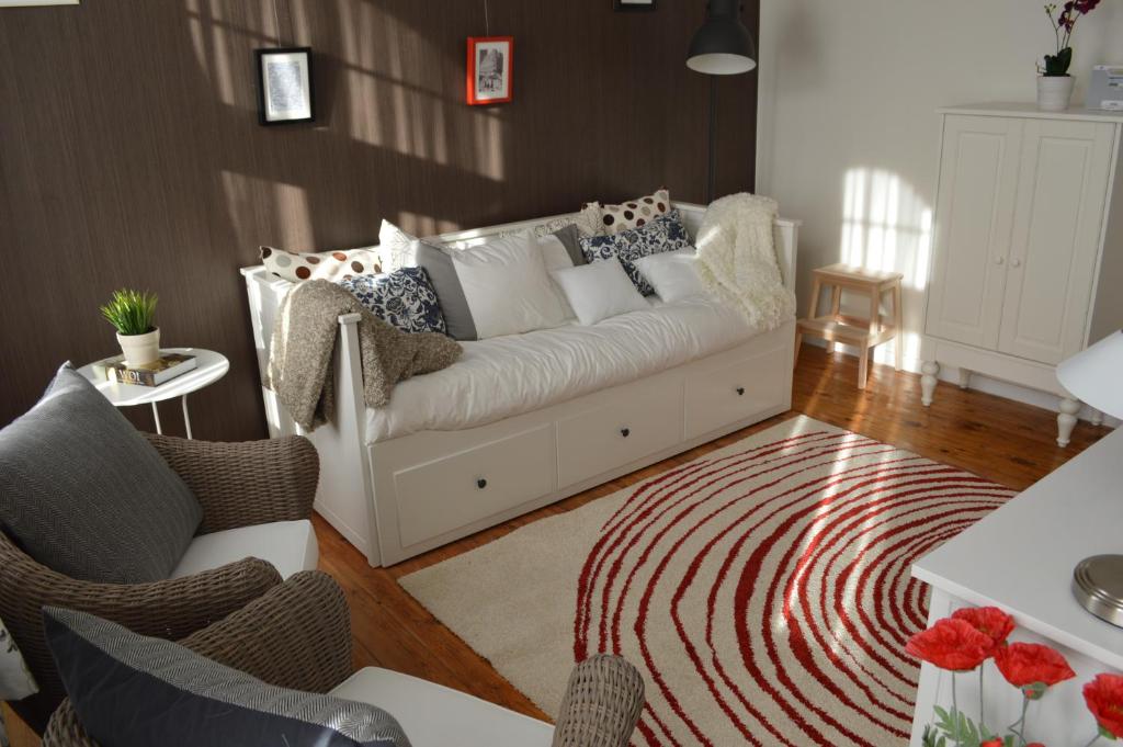 a living room with a white couch and a rug at Holiday Home Ipericus in Ieper