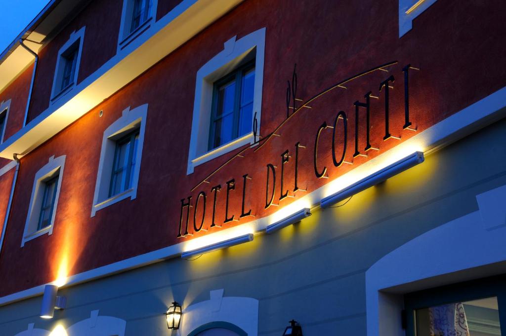 un cartello sul lato di un edificio con luci di Hotel Dei Conti a Castelnuovo di Val di Cecina