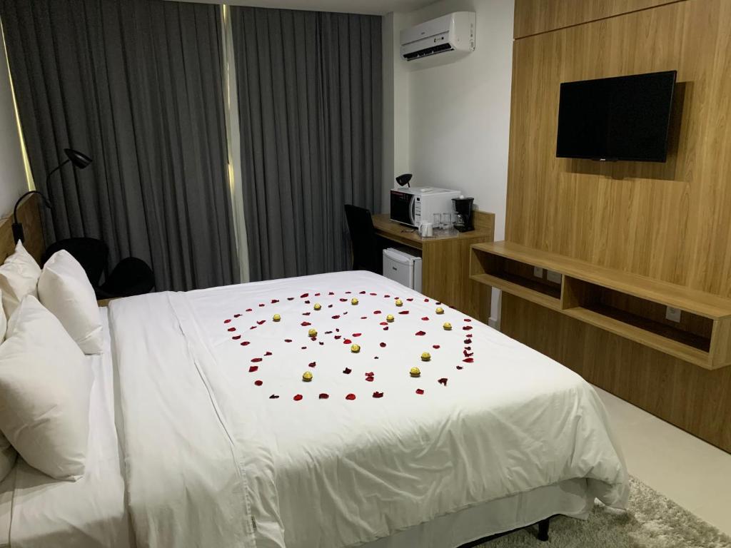 una habitación de hotel con una cama con pétalos de rosa roja. en Estudio Itaipava Suíte, en Itaipava