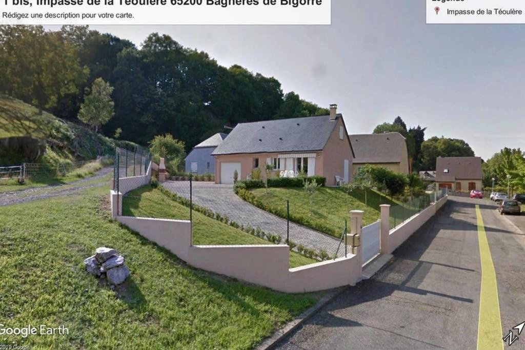 una casa sul ciglio di una strada con una recinzione di Petite maison aux abords de Bagnères de Bigorre a Bagnères-de-Bigorre