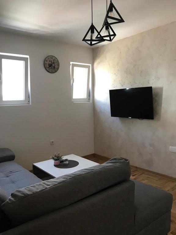 a living room with a couch and a flat screen tv at Apartman Tijana in Budva