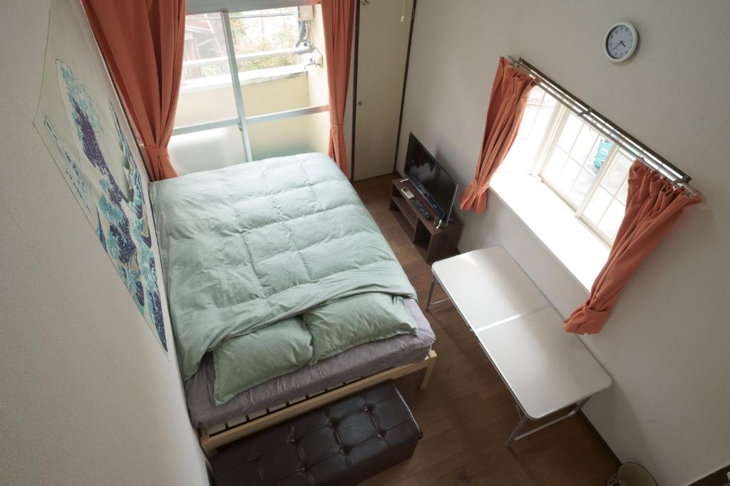 a small room with a bed and a window at Garden house Ozasa - Apartment STAY in Fukuoka