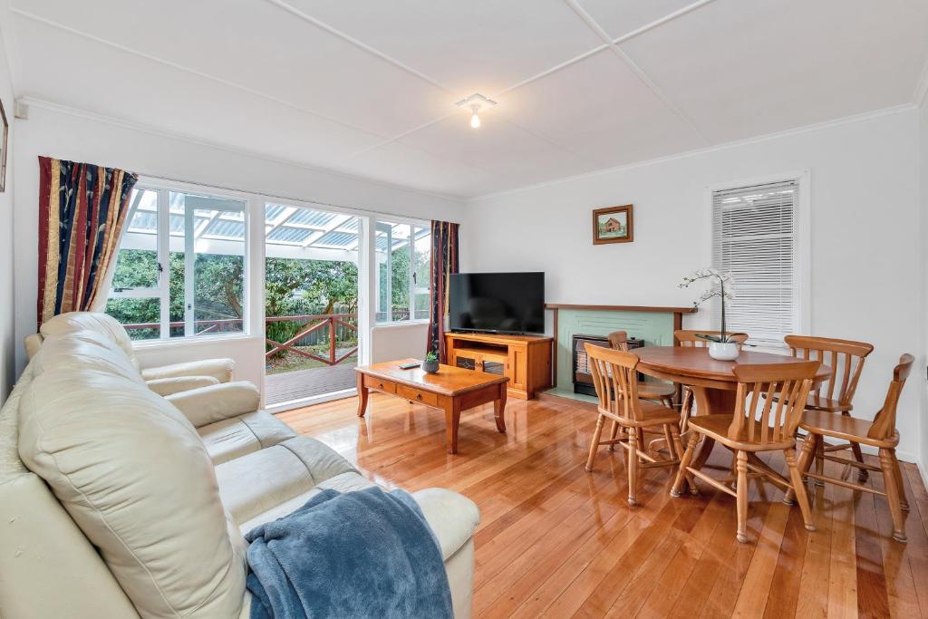 een woonkamer met een bank en een tafel bij 3 Bedroom In Onehunga w Parking - Wifi - Netflix in Auckland