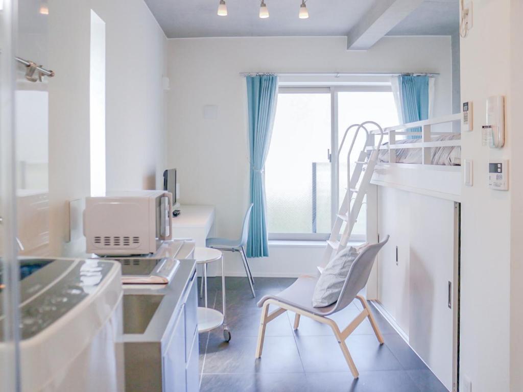 Habitación con silla y escritorio con ordenador. en Urbanage Takadanobaba apartment, en Tokio