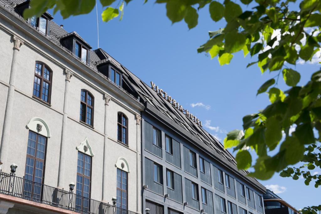 ein großes weißes Gebäude mit Fenstern darüber in der Unterkunft Thon Partner Hotel Victoria Hamar in Hamar