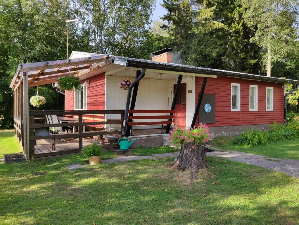 een rode en witte hut met een veranda bij KTU Kuntomaja in Kokkola