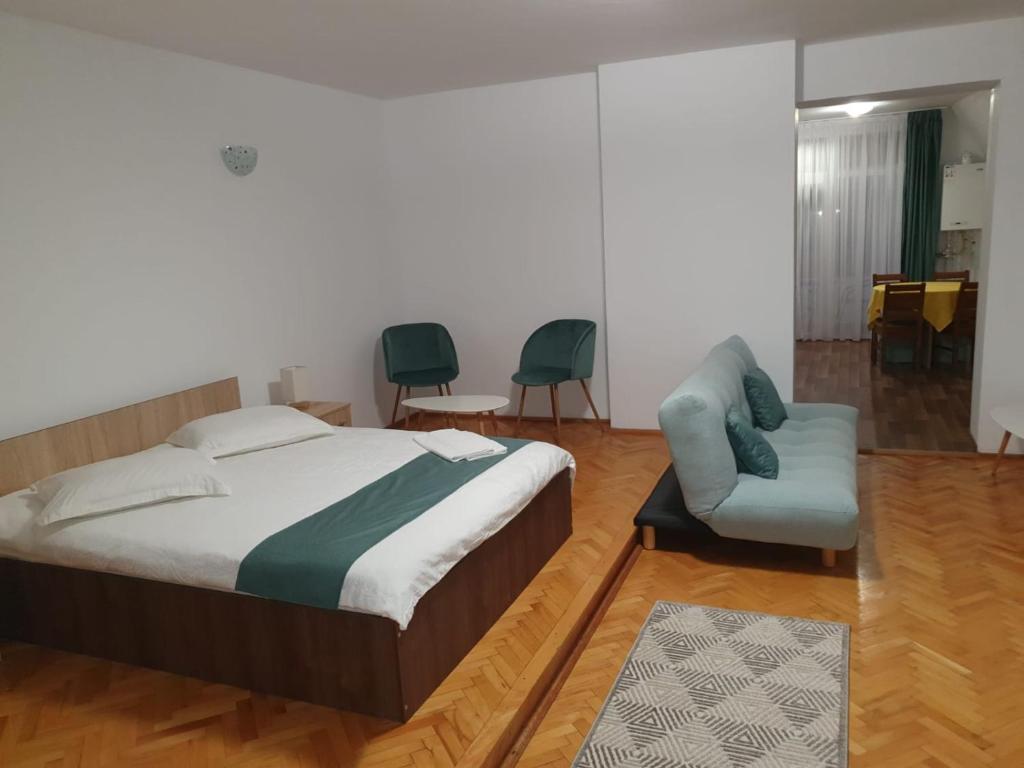 a bedroom with a bed and a chair and a table at STUDIO APARTMENTS in Alba Iulia